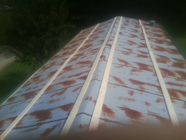 Rusted metal roof panels with new wood purlins before replacement — Storm Damage Roof Repair in Clinton by Roofing Brothers